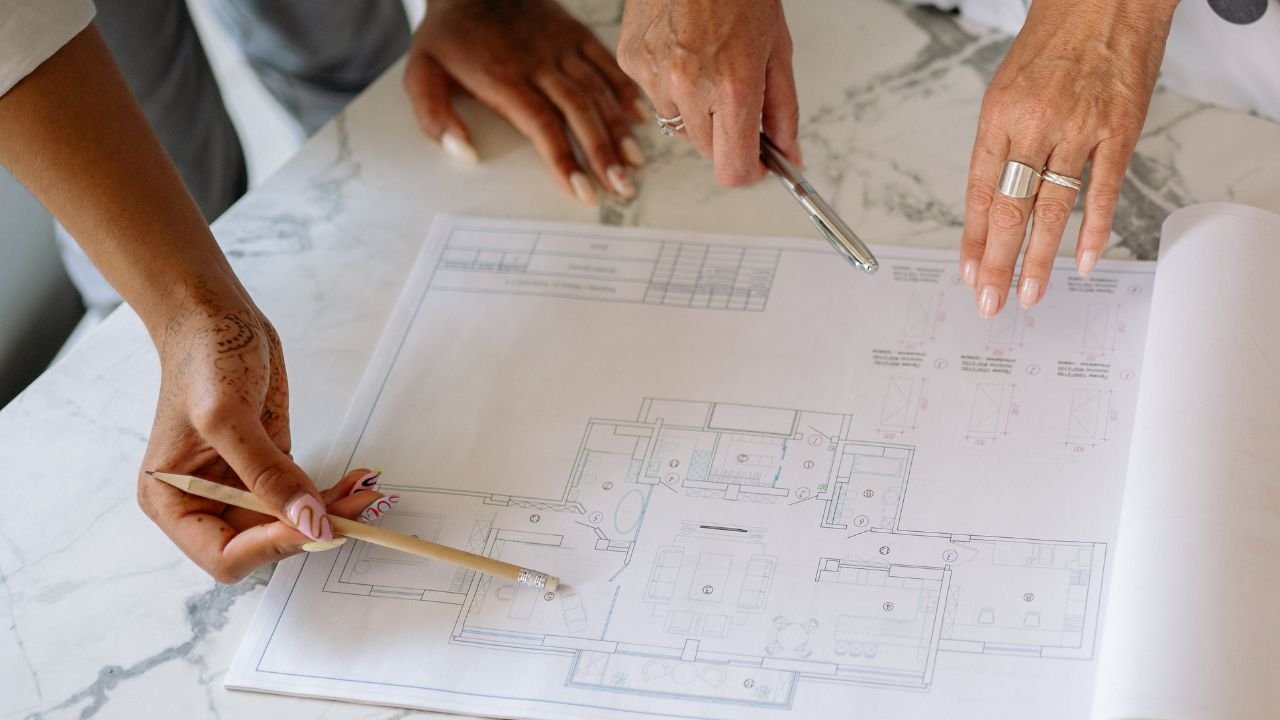 **Meta Title:** What Is Architectural Design in Construction? (Guide) **Meta Description:** Understand what architectural design in construction means. Learn the process, differences from structural design, and how it impacts building approvals in India. **Suggested URL Slug:** `/what-is-architectural-design-in-construction` --- # What Is Architectural Design in Construction? (Complete Guide for India) When you plan to build a house, a commercial complex, or an industrial facility, the term “architectural design” is everywhere. But when clients come to my office, I often find they are not fully clear on what it actually means. Many homeowners, and even some novice contractors, confuse architectural design with structural engineering, interior decoration, or simply “drawing a floor plan.” In reality, architectural design is the absolute foundation of any construction project. It is the complex process that translates your personal needs, challenging site conditions, and strict municipal regulations into a functional, safe, and aesthetically pleasing building. In my experience as an architect working on residential and commercial projects across India, the architectural design phase is where the real vision of the building takes shape. At **Construction Estimator India**, we regularly work alongside architects, engineers, and clients to turn these architectural designs into highly accurate Bill of Quantities (BOQs) and cost estimates, ensuring the beautiful vision is financially viable. By the end of this article, you will clearly understand what architectural design is, how the professional process works, how it differs from other engineering disciplines, and exactly how it connects to securing building plan approvals in India. --- ## What Is Architectural Design? (Simple Definition) In clear, non-technical language, **architectural design** is the creative and technical process of planning, organizing, and designing buildings and physical spaces. The goal is to ensure the final structure is functional, safe for occupants, environmentally sustainable, and aesthetically pleasing. It is a comprehensive process that involves: * **Understanding client requirements:** How many rooms are needed? What is the usage? What is the budget and lifestyle? * **Analyzing the site:** Studying the sun's orientation, local climate, road access, and surrounding topography. * **Developing layouts:** Creating spatial arrangements, forms, and external elevations. * **Coordination:** Acting as the master conductor to align structural, plumbing, and electrical consultants. * **Regulatory Compliance:** Ensuring the design strictly adheres to building codes and local municipal regulations. In simple terms, architectural design answers the fundamental questions of a project: * *“What will the building look like?”* * *“How will the spaces function and flow into one another?”* * *“How does the building fit on the plot and respond to the local climate?”* * *“Is it compliant with municipal bylaws and safe for occupants?”* For a formal global perspective, the [American Institute of Architects (AIA)](https://www.aia.org/) describes architectural design as the vital process of translating client needs and site conditions into a buildable, code-compliant design concept. In India, this process is led by an architect licensed by the [Council of Architecture (COA)](https://www.coa.gov.in/). --- ## Why Is Architectural Design Important in Construction? Why can't you just ask a local mason or draftsman to sketch a few rooms on a piece of paper? Here is why professional architectural design is critical. ### 1. Functional Planning and Space Optimization Good architectural design ensures that every expensive square foot of your plot is used efficiently. An architect ensures rooms are correctly proportioned, circulation spaces (corridors/stairs) are logical, and spaces are zoned properly (separating noisy public areas from quiet private zones). ### 2. Safety and Code Compliance Architects do not just draw pretty pictures; they design buildings to comply with the law. In India, this means adhering to the [National Building Code (NBC) of India](https://www.bis.gov.in/) published by the Bureau of Indian Standards (BIS). This covers mandatory setbacks, Floor Space Index (FSI), height restrictions, fire safety, and accessibility norms. ### 3. Aesthetics and Identity Architectural design defines the character of the building. Whether you want a modern glass facade, a traditional Kerala-style sloping roof, or a minimalist concrete aesthetic, the architect crafts how the building looks and how it fits into its neighborhood. ### 4. Coordination with Other Disciplines Architectural drawings are the "master blueprint." They become the base layer over which the structural engineer designs the columns and beams, the MEP engineer designs the plumbing and electrical lines, and the interior designer plans the furniture layouts. Without a master architectural plan, clashes on site are inevitable. ### 5. Basis for Approvals and Permits Building plan approval authorities primarily review architectural drawings. They check for compliance with setbacks, minimum room sizes, ventilation requirements, and parking provisions. Without proper architectural design, getting plan approval becomes legally impossible, exposing your project to demolition risks. --- ## Architectural Design vs Structural Design vs Interior Design A major source of confusion (*architectural design kya hota hai?*) is mixing up the different design professionals. Here is a clear breakdown of who does what. ### Architectural Design * **Focus:** Overall building form, spatial layout, aesthetics, code compliance, and user experience. * **Handles:** Floor plans, external elevations, building cross-sections, room sizing, door/window placement, and master coordination. * **Led by:** A licensed Architect. ### Structural Design * **Focus:** Ensuring the architectural shell is physically safe, stable, and can carry all loads (dead weight, live occupants, wind pressure, and seismic/earthquake forces). * **Handles:** Sizing of columns, beams, slabs, foundation depths, and detailed steel reinforcement calculations. * **Led by:** A Structural Engineer. ### Interior Design * **Focus:** How the internal spaces function, feel, and are finished for the end user. * **Handles:** Internal partitions, false ceiling designs, flooring materials, wall treatments, lighting moods, and Furniture, Fixtures & Equipment (FF&E). * **Led by:** An Interior Designer (often brought in after the architectural shell is finalized). **A Simple Analogy:** * **Architectural design** is designing the body, shape, and layout of a car. * **Structural design** is engineering the chassis and engine to ensure the car doesn't fall apart at high speeds. * **Interior design** is choosing the leather seats, the dashboard layout, and the sound system. ### Quick Comparison Table | Discipline | Primary Focus | Key Deliverables | Professional | | --- | --- | --- | --- | | **Architectural** | Form, function, layout, compliance | Floor plans, elevations, sections | Architect | | **Structural** | Safety, stability, load-bearing | Column/beam sizing, reinforcement detailing | Structural Engineer | | **Interior** | Internal aesthetics, finishes, comfort | Furniture layouts, false ceilings, material palettes | Interior Designer | *(For further reading on how professional bodies define these roles globally, visit the [Royal Institute of British Architects (RIBA)](https://www.architecture.com/).)* --- ## The Architectural Design Process – Step by Step The architectural design process is highly structured. In India, professional practice is guided by the Council of Architecture. Here are the typical stages of a project: ### 1. Pre-Design / Inception (Client Brief & Site Analysis) Before drawing a single line, the architect must understand you and your land. * **Client Brief:** Gathering requirements—family size, commercial targets, budget, and future expansion plans. * **Site Analysis:** Studying the plot's sun path, wind direction, topography, and surrounding structures. * **Deliverables:** A design brief document and a preliminary feasibility note (what can legally be built based on local FSI). ### 2. Concept Design This is where the client’s vision starts taking shape. * **Process:** The architect develops initial spatial layouts, massing, and orientation studies. You will usually be presented with 2 or 3 concept options. * **Deliverables:** Concept floor plans, basic external elevations, and 3D views. At this stage, a rough cost estimate based on the built-up area is generated. ### 3. Preliminary Design / Design Development Once a concept is chosen, it is fleshed out into a realistic building. * **Process:** The approved concept is refined. Exact wall thicknesses, door locations, and basic material palettes are chosen. * **Deliverables:** Detailed floor plans, elevations, and coordination inputs are sent to the structural and MEP consultants. ### 4. Client & Statutory Approvals This is the legal hurdle. The architect prepares a specific set of drawings formatted purely for the local municipality or development authority. * **Process:** The drawings demonstrate compliance with all local bylaws (setbacks, height, fire safety). * *For a detailed understanding of how architectural drawings are scrutinized during this phase, you can read our comprehensive guide on [building plan approval in India](https://constructionestimatorindia.com/building-plan-approval-india/).* ### 5. Working Drawings & Tender (GFC) Approval drawings are not detailed enough to build from. The architect must now create "Good For Construction" (GFC) drawings. * **Process:** Producing highly detailed plans, sections, and joinery details. The architect coordinates the final structural and MEP drawings into one master set. * **Tendering:** The architect and cost consultant prepare a Bill of Quantities (BOQ) to invite contractor bids. * *At Construction Estimator India, we frequently step in at this stage, working alongside architects to prepare highly accurate BOQs and cost estimates based on these detailed working drawings.* ### 6. Construction Phase (Site Supervision) The architect's job doesn't end when construction begins. * **Process:** The architect visits the site at key milestones (foundation, slab casting, finishing) to ensure the contractor is executing the work exactly as per the design intent. They resolve site queries and approve material mock-ups. ### 7. Completion & Handover * **Process:** Conducting a final inspection (snag list), providing as-built drawings if requested, and assisting the client in obtaining the final Occupancy Certificate (OC) from the municipality. *(Note: The [Indian Institute of Architects (IIA)](https://indianinstituteofarchitects.com/) strongly advocates following these structured stages to ensure ethical and professional project delivery).* --- ## How Architectural Design Connects to Building Plan Approval & Construction Permits Many clients view architectural design purely as an exercise in aesthetics (*ghar ka design*). This is a massive misconception. Architectural design is primarily a legal and technical requirement. When you submit your project to a municipal corporation (like BMC in Mumbai or BBMP in Bangalore), the approval authorities primarily review the **architectural drawings**. They do not usually check the interior design, and they only do a cursory check of the structural safety certificate. They are looking to see if your architect has complied with the law: * **Setbacks:** Are you leaving the mandatory open space on all four sides of the building? * **FSI / FAR:** Is your total built-up area within the legal limit for your plot size? * **Ventilation & Light:** Do your rooms and bathrooms meet the minimum size and window-area requirements? * **Access & Parking:** Have you provided enough parking slots and an adequately wide driveway for fire engines? Without professionally prepared and approved architectural plans, you cannot legally start construction. Attempting to do so risks heavy penalties, demolition drives, or the inability to secure permanent water and electricity connections. *If you are preparing to navigate this bureaucratic process, our step-by-step guide on [how to get a construction permit in India](https://constructionestimatorindia.com/how-to-get-construction-permit-india/) explains all the documents, NOCs, and timelines involved.* --- ## Common Mistakes in Architectural Design (and How to Avoid Them) After reviewing hundreds of projects, I consistently see the same costly mistakes made by clients during the architectural design phase: 1. **Skipping Professional Architectural Services:** Relying on a local contractor or draftsman to "copy a plan" usually leads to poor ventilation, wasted space, severe code violations, and costly demolition notices later. 2. **Not Aligning Design with Budget:** Demanding complex, curved facades or massive cantilevered balconies without consulting a cost estimator. This results in a beautiful design that you cannot afford to build. 3. **Ignoring Site and Climate:** Forcing a glass-heavy, Western-style architectural design into a hot Indian climate without proper sun-shading, resulting in unbearable heat and massive air-conditioning bills. 4. **Poor Coordination with Structural and MEP:** Finalizing the architectural plan without showing it to a structural engineer, only to find out later that a massive column must be placed right in the middle of your living room. 5. **Not Planning for Approvals:** Pushing the architect to illegally cover the setbacks to gain more room size. This inevitably leads to rejection or endless delays in the plan approval process. 6. **Changing Design Mid-Construction:** Deciding to move a bathroom or widen a room *after* the foundation has been poured. This causes massive rework, cost escalation, and contractor disputes. 7. **Focusing Only on Looks:** Prioritizing how the building looks from the outside (elevation) over how it functions on the inside (plan), leading to impractical, uncomfortable living or working spaces. --- ## FAQs **What is architectural design in construction?** Architectural design is the comprehensive process of planning a building's layout, form, functionality, and compliance with local laws, serving as the master blueprint for the entire construction project. **How is architectural design different from structural design?** Architectural design focuses on the layout, aesthetics, and functionality of the building. Structural design focuses entirely on the math and physics required to make that architectural layout safe, stable, and capable of bearing weight. **What are the main stages of the architectural design process?** The typical stages are: Pre-Design (briefing), Concept Design, Design Development, Statutory Approvals, Working Drawings (GFC), Site Supervision, and Handover. **Who prepares architectural design drawings in India?** Professional architectural drawings required for municipal approvals must be prepared and signed by an Architect who holds a valid license from the Council of Architecture (COA) India. **Is architectural design required for building plan approval?** Yes. Municipal authorities exclusively review architectural drawings to ensure the proposed building complies with local zoning laws, FSI, setbacks, and fire safety norms before granting a construction permit. **Can I start construction without architectural design?** No. Starting construction without approved architectural plans is illegal in urban and semi-urban India and can lead to the demolition of your structure. **How does architectural design impact construction cost?** The architect's decisions—such as the complexity of the building shape, the number of floors, the ceiling heights, and the facade materials—dictate the baseline cost of the entire project before a single brick is laid. --- ## Conclusion **Architectural design in construction** is far more than just drawing a pretty floor plan. It is the foundational, multi-disciplinary process that translates your specific needs, the harsh realities of your site, and strict municipal regulations into a functional, safe, and beautiful building. While architectural design focuses on space, form, and compliance, it must work in perfect harmony with structural engineering (for safety) and interior design (for comfort). In India, engaging a qualified, COA-registered architect from day one is not just a best practice—it is a legal necessity for securing your building plan approvals and construction permits. Remember, the cheapest part of any construction project is the paper it is drawn on. Investing time and money into a rigorous architectural design process prevents disastrous mistakes, budget overruns, and legal headaches once the concrete starts pouring. **Want to ensure your architect's vision aligns with your budget?** Do not let complex designs derail your finances. Contact **Construction Estimator India** for professional cost estimation, accurate BOQ preparation, and expert coordination support between your architectural and structural teams. Visit [Construction Estimator India](https://constructionestimatorindia.com) today to keep your project safely under budget!